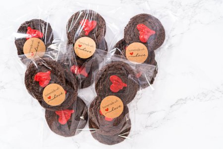 Foto de Galletas de chocolate con corazones de chocolate para el Día de San Valentín empaquetadas en bolsas de regalo de plástico. - Imagen libre de derechos