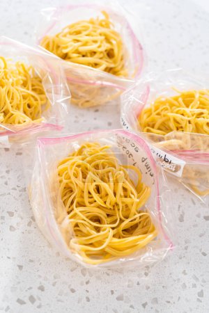 Photo for Packaging homemade frozen shrimp scampi meal prep into plastic resealable bags. - Royalty Free Image