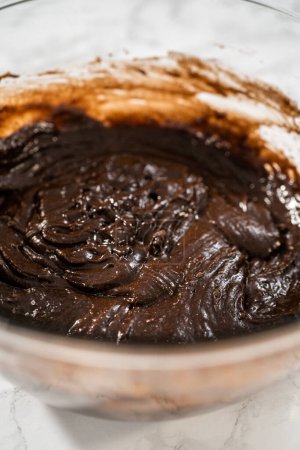 Téléchargez les photos : Mélanger les ingrédients dans un grand bol de mélange en verre pour cuire des cupcakes à la menthe poivrée au chocolat. - en image libre de droit