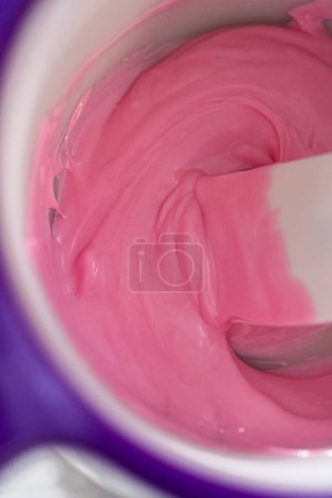 Foto de Derretimiento de chips de chocolate rosa en un crisol de dulces para hacer lazos de chocolate para galletas de shortbread en forma de panda. - Imagen libre de derechos