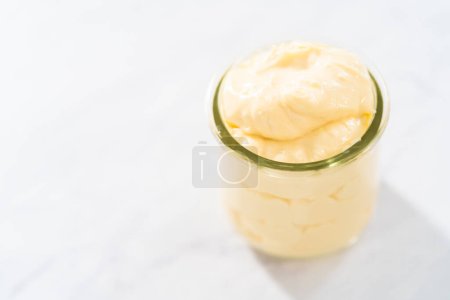 Téléchargez les photos : Remplissage fromage à la crème pour gâteau bundt en petit pot de verre. - en image libre de droit