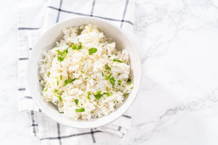 Photo for Cilantro Lime Rice. Serving cilantro lime rice garnished with fresh parsley in white ceramic bowls. - Royalty Free Image