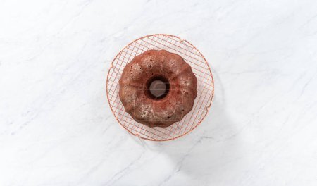 Photo for Flat lay. Cooling freshly baked red velvet bundt cake on a kitchen counter. - Royalty Free Image