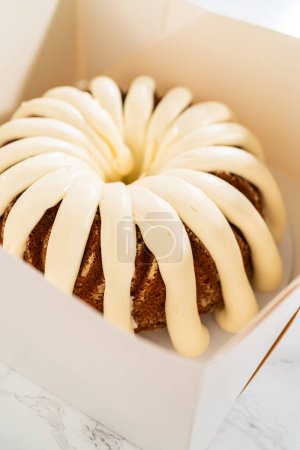 Téléchargez les photos : Les gâteaux bundt fraîchement cuits sont soigneusement nichés dans des boîtes en papier blanc, les préparant pour un transport sûr tout en conservant leur apparence délectable. - en image libre de droit