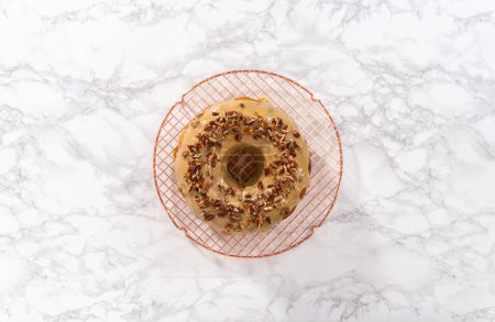 Photo for Flat lay. Frosting pumpkin bundt cake with a toffee glaze and garnish with toasted pecans. - Royalty Free Image