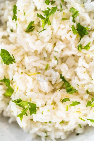 Photo for Cilantro Lime Rice. Serving cilantro lime rice garnished with fresh parsley in white ceramic bowls. - Royalty Free Image