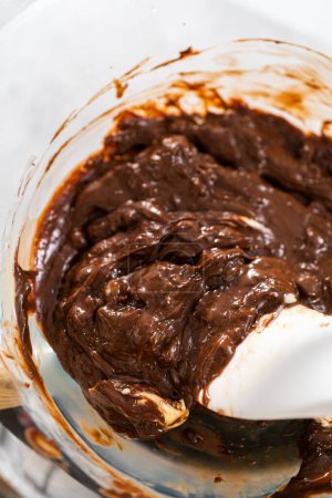 Foto de Derretir chispas de chocolate blanco y otros ingredientes en un recipiente de mezcla de vidrio sobre agua hirviendo para preparar caramelo fudge caña. - Imagen libre de derechos
