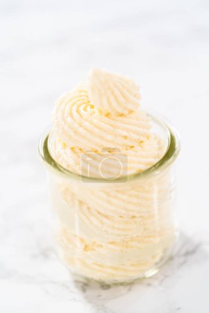 Photo for White chocolate ganache frosting in a small glass mason jar. - Royalty Free Image