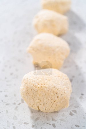 Foto de Rolling masa de pan con un rodillo francés para hornear naan dippers. - Imagen libre de derechos