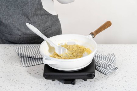 Téléchargez les photos : Faire frire les œufs sur une poêle antiadhésive pour faire des empanadas petit déjeuner avec des œufs et des patates douces. - en image libre de droit