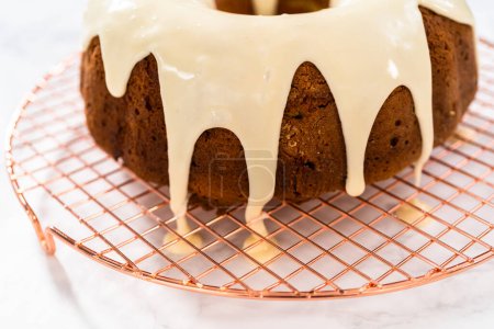 Foto de Pouring homemade eggnog glaze over freshly baked eggnog bundt cake. - Imagen libre de derechos
