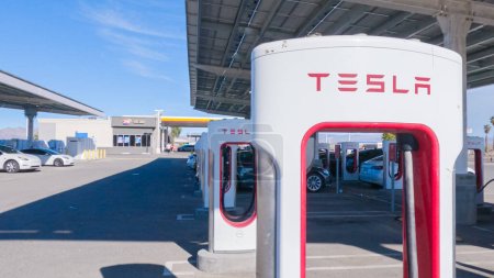 Photo for Baker, California, USA-December 3, 2022-During the day, a Tesla vehicle is seen charging at a Tesla Supercharging station, utilizing the high-speed charging infrastructure for convenient and efficient - Royalty Free Image