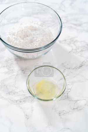 Foto de Ingredientes medidos en cuencos de vidrio para hacer el glaseado de limón. - Imagen libre de derechos