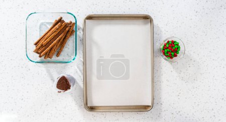 Téléchargez les photos : Denver, Colorado, USA-18 décembre 2022-Pose à plat. Tremper les tiges de bretzel dans le chocolat fondu et saupoudrer de bonbons pour faire des tiges de bretzel recouvertes de chocolat. - en image libre de droit