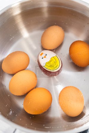Photo for Boiling brown organic eggs in a cooking pot to prepare hard-boiled eggs. - Royalty Free Image