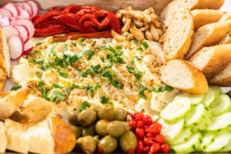 Photo for A large vegetarian party butter board with fresh and pickled vegetables and sliced french baguette for a party. - Royalty Free Image
