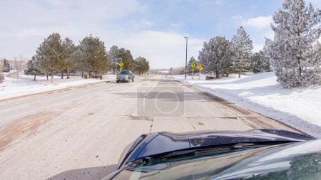 Photo for Castle Pines, Colorado, USA-January 30, 2023-Traversing a freshly cleared, suburban road after a winter storm, one experiences a serene drive through an upscale residential neighborhood. Snow-covered - Royalty Free Image