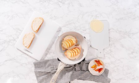 Foto de Flat lay. Prepare provolone and apple grilled cheese sandwich on a nonstick frying pan. - Imagen libre de derechos