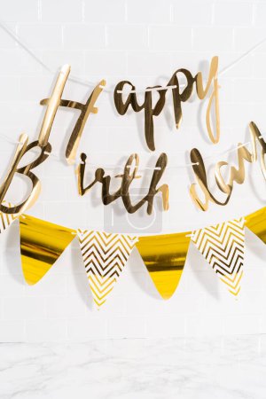 Téléchargez les photos : Papier Happy Birthday bannière en papier doré dans la cuisine. - en image libre de droit