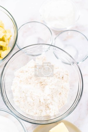 Téléchargez les photos : Ingrédients mesurés dans un bol à mélanger en verre pour cuire le gâteau bundt aux pommes avec glaçure au caramel. - en image libre de droit