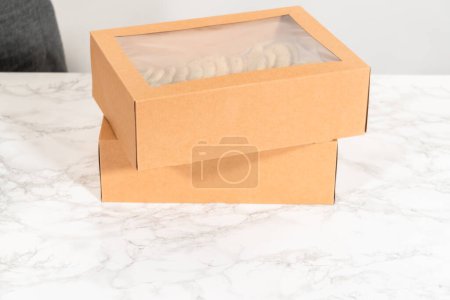 Foto de Las galletas de azúcar, rellenas de aspersiones mezcladas en la masa, se colocan cuidadosamente con precisión meticulosa en una caja de papel marrón rústico. - Imagen libre de derechos