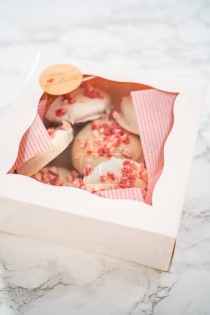 Téléchargez les photos : Emballage de biscuits au chocolat blanc à la menthe poivrée fraîchement cuits dans une boîte en papier blanc. - en image libre de droit
