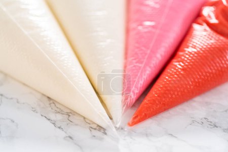 Photo for Homemade royal icing in piping bags ready to decorate sugar cookies on the kitchen counter. - Royalty Free Image