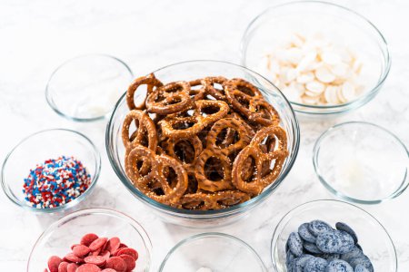 Photo for Measured ingredients in glass mixing bowls to prepare red, white, and blue chocolate-covered pretzel twists. - Royalty Free Image