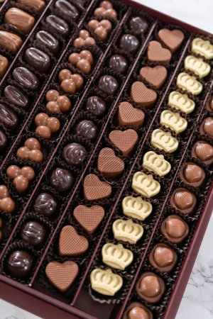 Téléchargez les photos : Boîte de chocolats gastronomiques assortis dans une grande boîte. - en image libre de droit