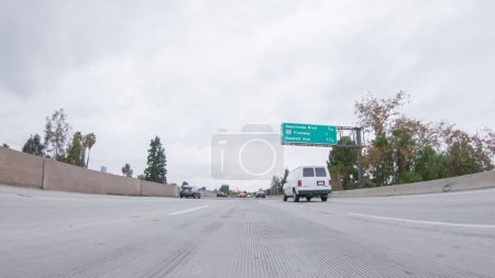 Foto de Los Angeles, California, USA-December 4, 2022-POV-En medio de un día lluvioso de invierno, conduciendo en HWY 134 cerca de Los Ángeles, California, captura la atmósfera a través de lentes cubiertas por gotas de lluvia, agregando un único - Imagen libre de derechos
