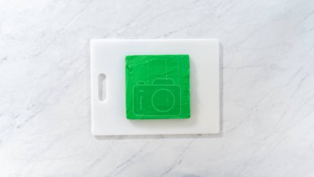 Téléchargez les photos : Pose plate. Marquer le caramel vert en carrés parfaits pour la coupe. - en image libre de droit