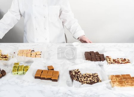 Photo for Packaging a homemade variety of fudge for Christmas food gifts into tin boxes. - Royalty Free Image