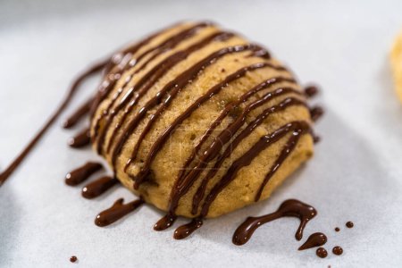 Photo for Drizzling melted chocolate over banana cookies. - Royalty Free Image