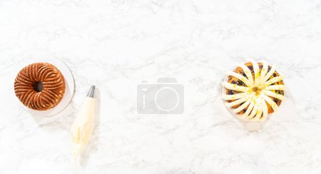 Photo for Flat lay. The final stage of this delightful baking journey involves artistically piping the silky cream cheese buttercream frosting atop the cooled bundt cakes, creating an irresistible treat. - Royalty Free Image