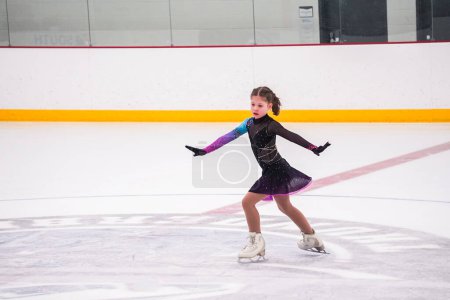 Foto de Niña practicando antes de su competición de patinaje artístico en la pista de hielo interior. - Imagen libre de derechos