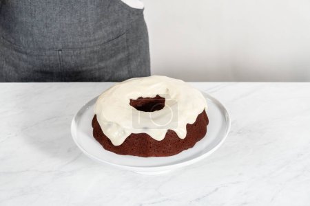 Foto de Decorating red velvet bundt cake with chocolate lips and hearts over cream cheese glaze. - Imagen libre de derechos