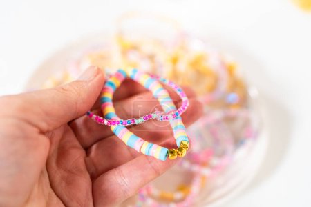 Téléchargez les photos : Petites filles charmants bracelets ornés de perles d'argile et de mer. - en image libre de droit