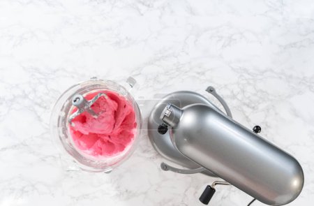 Foto de Acostado. Mezcla de ingredientes en la cocina mezclador eléctrico para hacer ombre rosa crema de mantequilla glaseado. - Imagen libre de derechos
