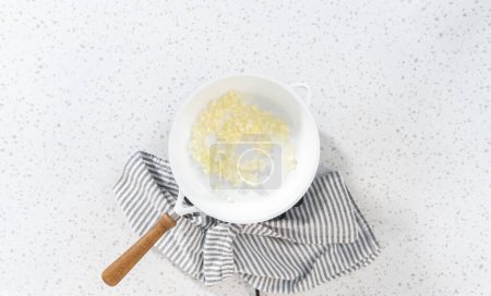 Téléchargez les photos : Pose plate. Faire frire l'oignon sur une poêle antiadhésive pour faire des empanadas petit déjeuner avec des œufs et des patates douces. - en image libre de droit
