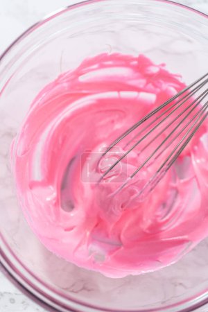 Téléchargez les photos : Mélange de colorant alimentaire rose dans la meringue pour cuire des biscuits meringue de Pâques. - en image libre de droit