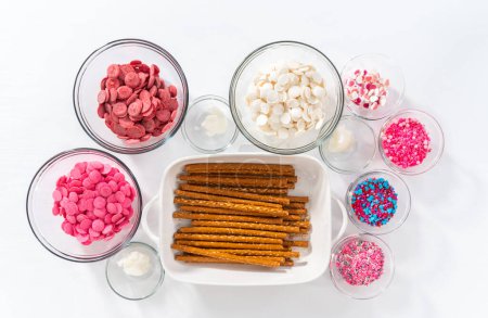 Flat lay. Measured ingredients in glass mixing bowls to make chocolate covered pretzel rods for Valentines Day.
