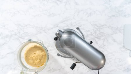 Téléchargez les photos : Mélange d'ingrédients dans un mélangeur de cuisine pour faire cuire mini pain de Pâques kulich. - en image libre de droit