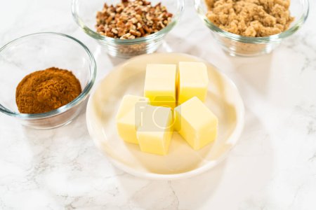 Téléchargez les photos : Ingrédients mesurés dans des bols à mélanger en verre pour cuire des petits gâteaux à la cannelle sans levure. - en image libre de droit