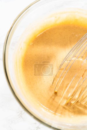 Photo for In a large glass bowl, the ingredients are expertly mixed to create the batter for baking the scrumptious Carrot Bundt Cake. - Royalty Free Image
