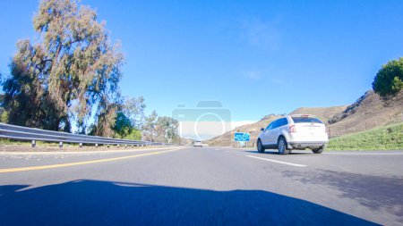 Téléchargez les photos : Santa Maria, Californie, États-Unis-6 décembre 2022-Par une belle journée d'hiver, une voiture parcourt l'emblématique Highway 1 près de San Luis Obispo, en Californie. Le paysage environnant est brunâtre et tamisé, avec - en image libre de droit