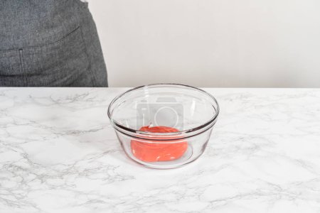 Téléchargez les photos : Mélanger les ingrédients dans un grand bol à mélanger en verre pour faire du glaçage royal fait maison. - en image libre de droit