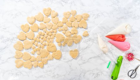 Foto de Acostado. Decoración de galletas de azúcar en forma de corazón con glaseado real rosa y blanco para el Día de San Valentín. - Imagen libre de derechos