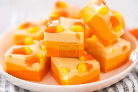 Téléchargez les photos : Bonbons faits maison morceaux carrés de caramel de maïs sur une plaque blanche. - en image libre de droit