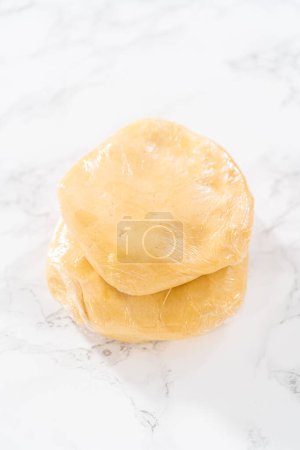 Foto de Envolver la masa de galletas en una envoltura de celofán para transferirla al refrigerador para enfriarla.. - Imagen libre de derechos
