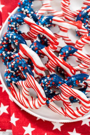 Téléchargez les photos : American flag. Red, white, and blue chocolate-covered pretzel twists. - en image libre de droit